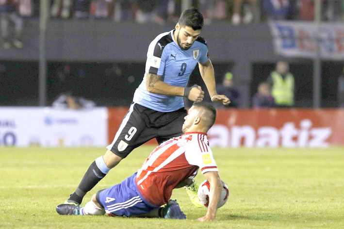 Uruguay ganó en Asunción por primera vez en un partido en el que los goles llegaron en la parte final. En la imagen Richard Ortiz (d) de Paraguay disputa el balón con Luis Suárez.
