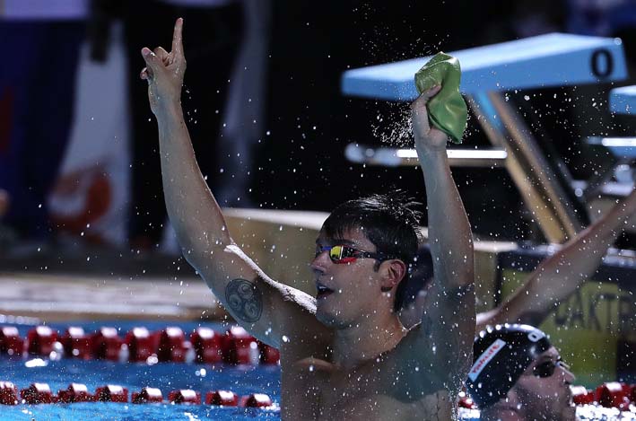 Jorge Mario Murillo celebra luego de vencer en la prueba de 100 metros pecho de natación masculina. EFE.