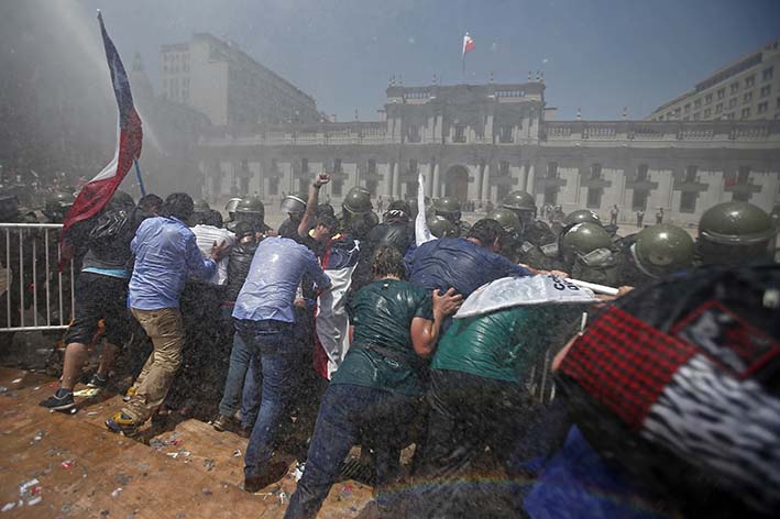 La policía antimotines improvisó un escudo frente al palacio de gobierno de La Moneda para contener a la multitud.