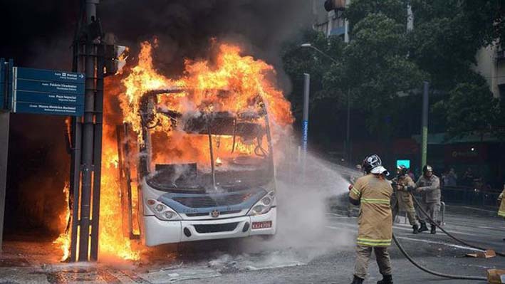 Bomberos tratan de apagar el fuego que consumió el bus.