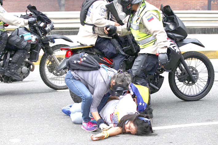 Una mujer es ayudada por un compañero anti-gobierno manifestante durante los enfrentamientos con las fuerzas de seguridad.