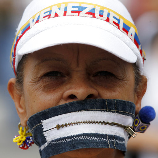 Un manifestante anti-gobierno cubre su boca con una cremallera durante una marcha de mujeres contra la represión en Caracas