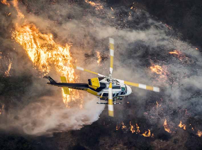Un helicóptero de bomberos del Condado de Los Ángeles sobrevuela un gran incendio en Bel Air, California (EE.UU.). 