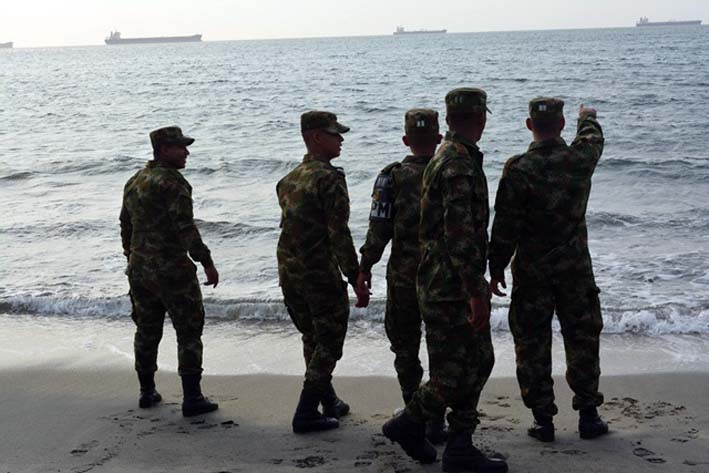 Un pequeño grupo de los 12 soldados que llegaron, miran asombrados hacia el firmamento en el mar.