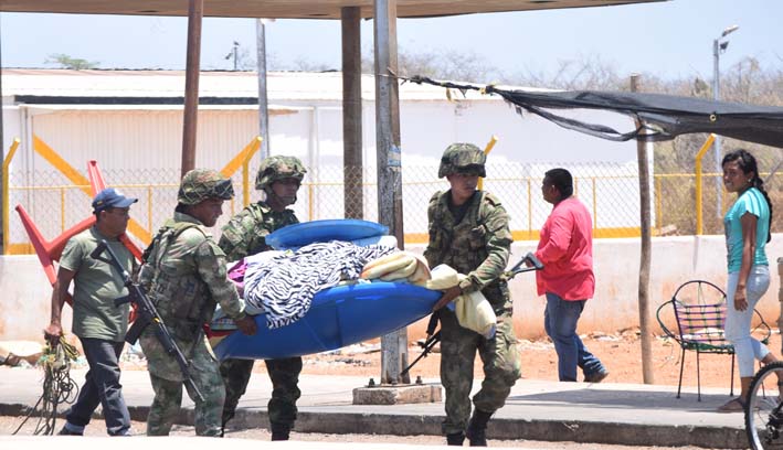 Soldados colombianos ayudan a subir los enseres a un camión de una familia colombiana que quedó en la frontera venezolana sin ayuda.