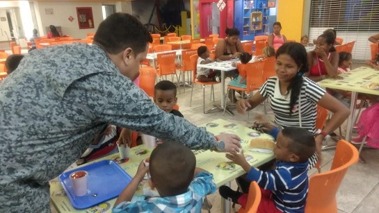 Un miembro de la Fauerza Aérea interactuando con los niños.