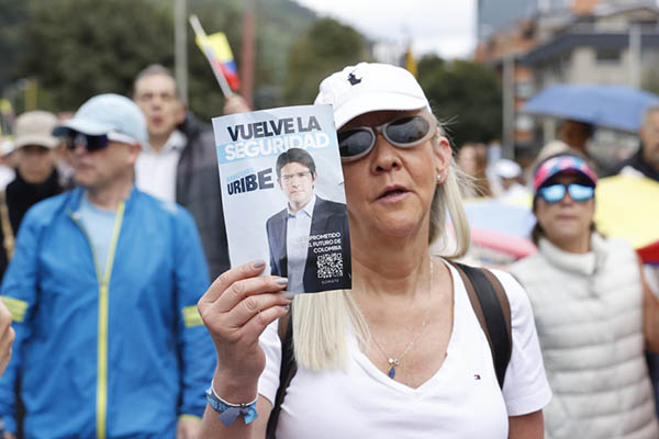 Una mujer sostiene un cartel durante una caminata por la paz y en apoyo al senador Miguel Uribe Turbay este domingo, en Bogotá. EFE/ Mauricio Dueñas Castañeda