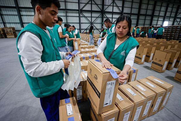 Personas alistan paquetes electorales del referéndum y de la consulta popular 2025 en Quito (Ecuador). EFE/ José Jácome