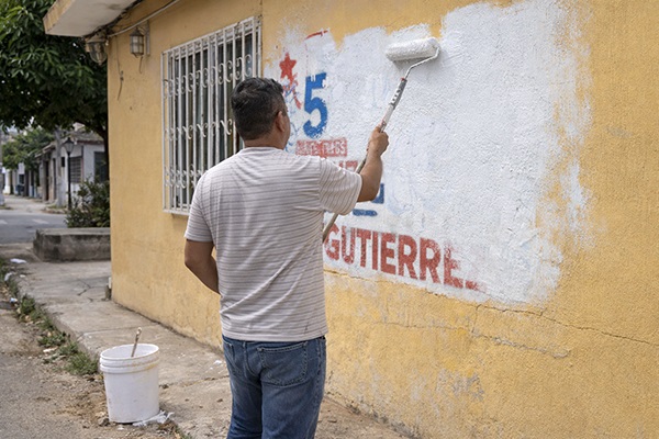 Habitante de Barraquilla, tapando una publicidad política de la fachada de su casa. Foto cortesía líderes barriales