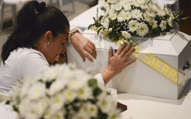 Una mujer lamenta a un familiar durante un velatorio de 21 víctimas del conflicto colombiano, cuyos restos fueron encontrados en diferentes fosas comunes, en Medellín (Antioquia), en agosto de 2017.