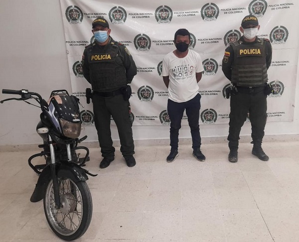 Ladrón de la moto posando junto a los oficiales de la policía 