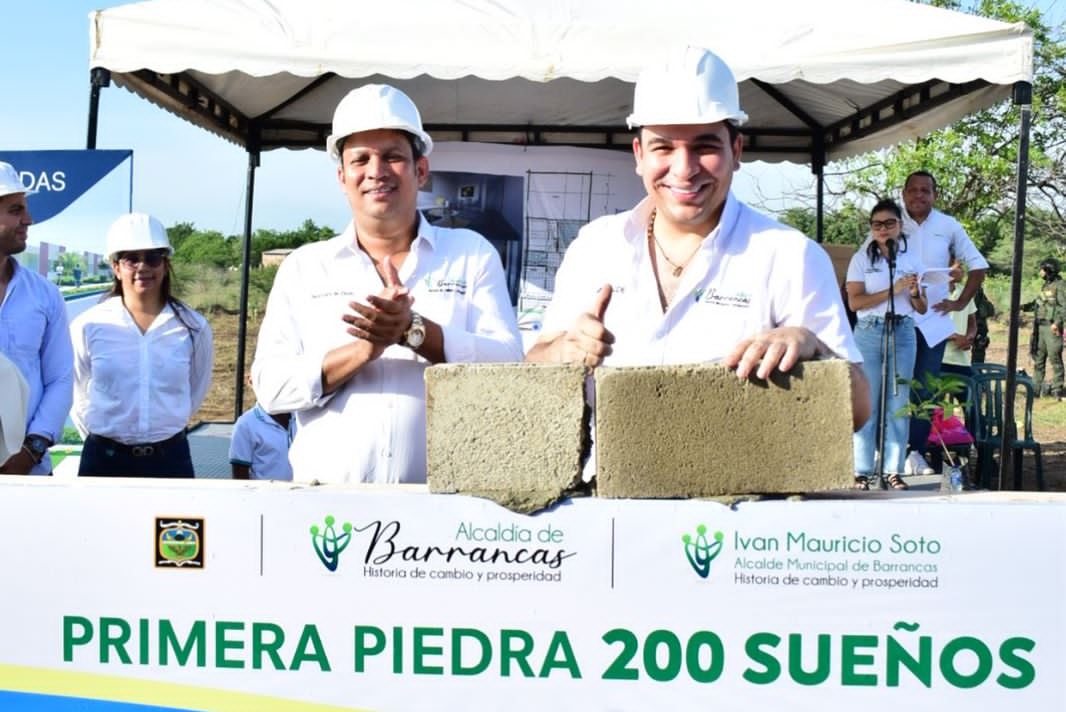 El alcalde con el palaustre en la mano, colocándole mescla al bloque, en señal de la primera piedra del proyecto que comienza a construir 200 viviendas para sus habitantes.