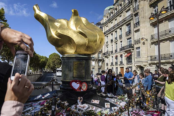 Varias personas dejan flores y fotografías en el monumento de la Llama de la Libertad sobre el puente del Almá en honor a la difunta princesa británica Diana de Gales, en París (Francia).